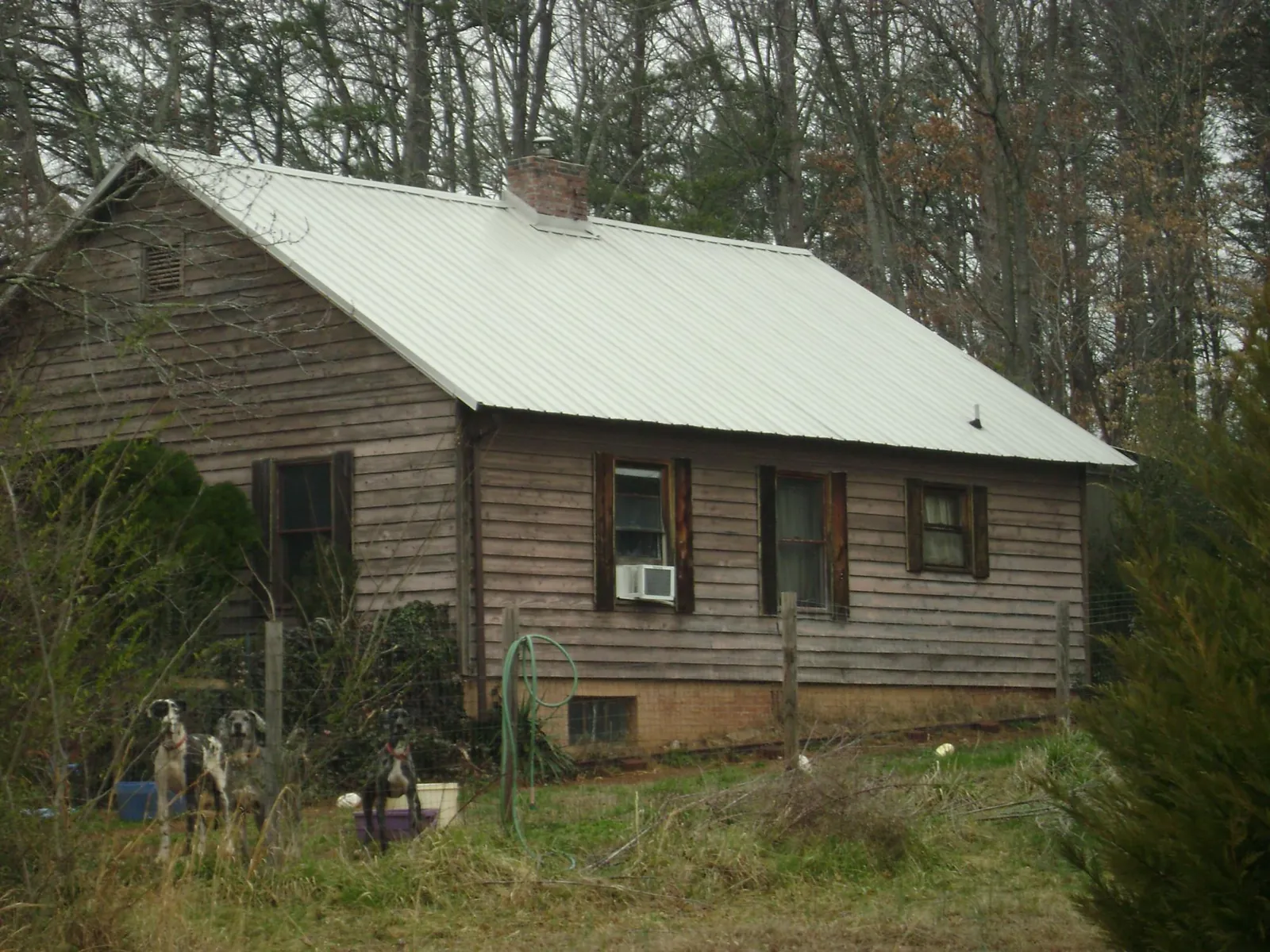 White metal roof on an old wood sided farmhouse, from a Metal Roof Installation job in Crescent